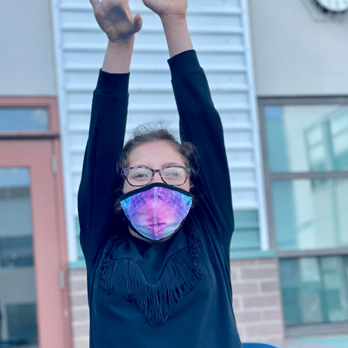 Emma standing outside with paint covered hands