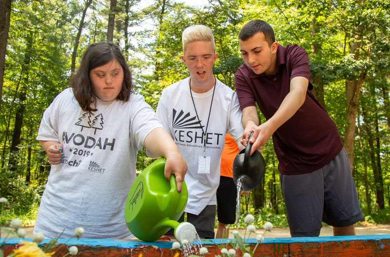 group of campers watering flowers outdoors