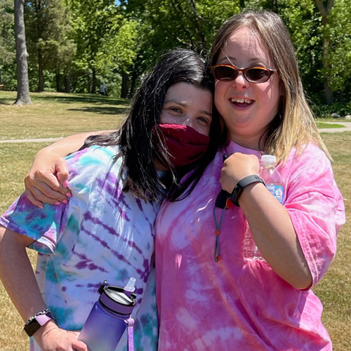 two girls hugging outdoors 